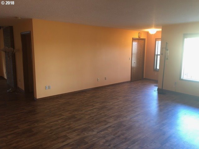 7635 Southeast Barbara Welch Road Portland, OR 97236 - Photo 3 of 26 a view of an empty room with wooden floor and a window