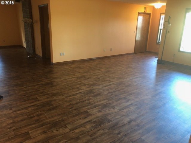 7635 Southeast Barbara Welch Road Portland, OR 97236 - Photo 4 of 26 a view of an empty room with wooden floor and a window