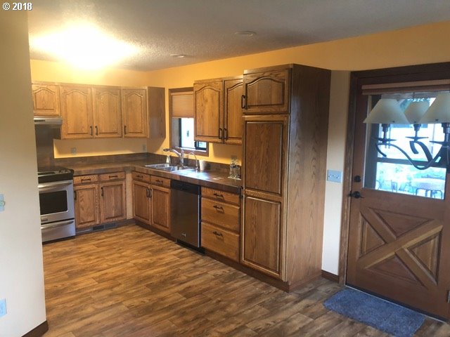 7635 Southeast Barbara Welch Road Portland, OR 97236 - Photo 5 of 26 a kitchen with stainless steel appliances granite countertop a refrigerator and a sink
