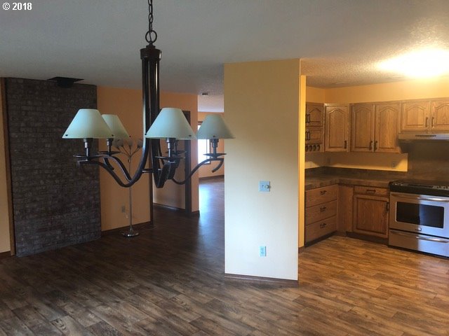 7635 Southeast Barbara Welch Road Portland, OR 97236 - Photo 6 of 26 a kitchen with kitchen island granite countertop a stove a sink and a refrigerator