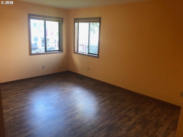7635 Southeast Barbara Welch Road Portland, OR 97236 - Photo 7 of 26 a view of an empty room with wooden floor and a window