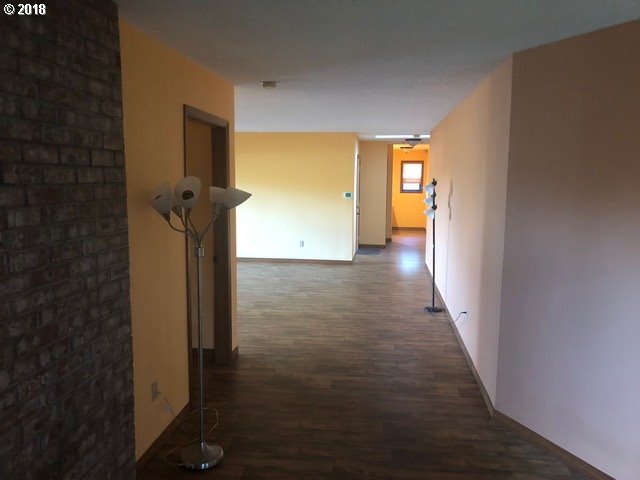 7635 Southeast Barbara Welch Road Portland, OR 97236 - Photo 9 of 26 a view of a hallway with wooden floor and a bathroom