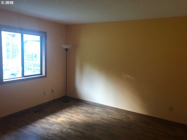 7635 Southeast Barbara Welch Road Portland, OR 97236 - Photo 10 of 26 an empty room with wooden floor and windows