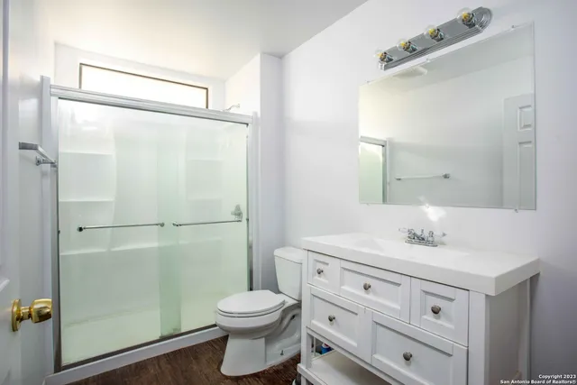 a bathroom with a granite countertop sink toilet and shower