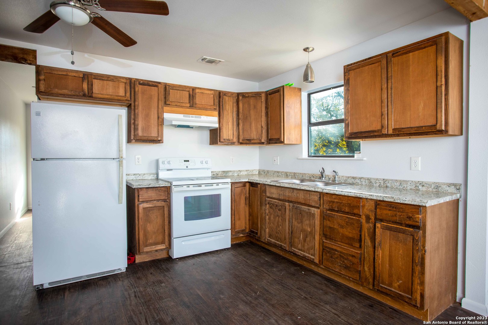 46 Fm 1621 Comfort, TX 78013 - Photo 7 of 48 a kitchen with stainless steel appliances granite countertop a refrigerator a sink dishwasher a stove with wooden cabinets