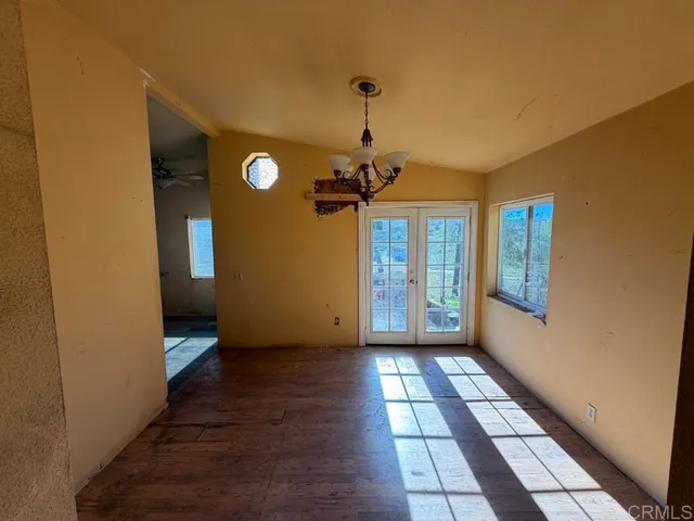 a view of a hallway with wooden floor and a living room