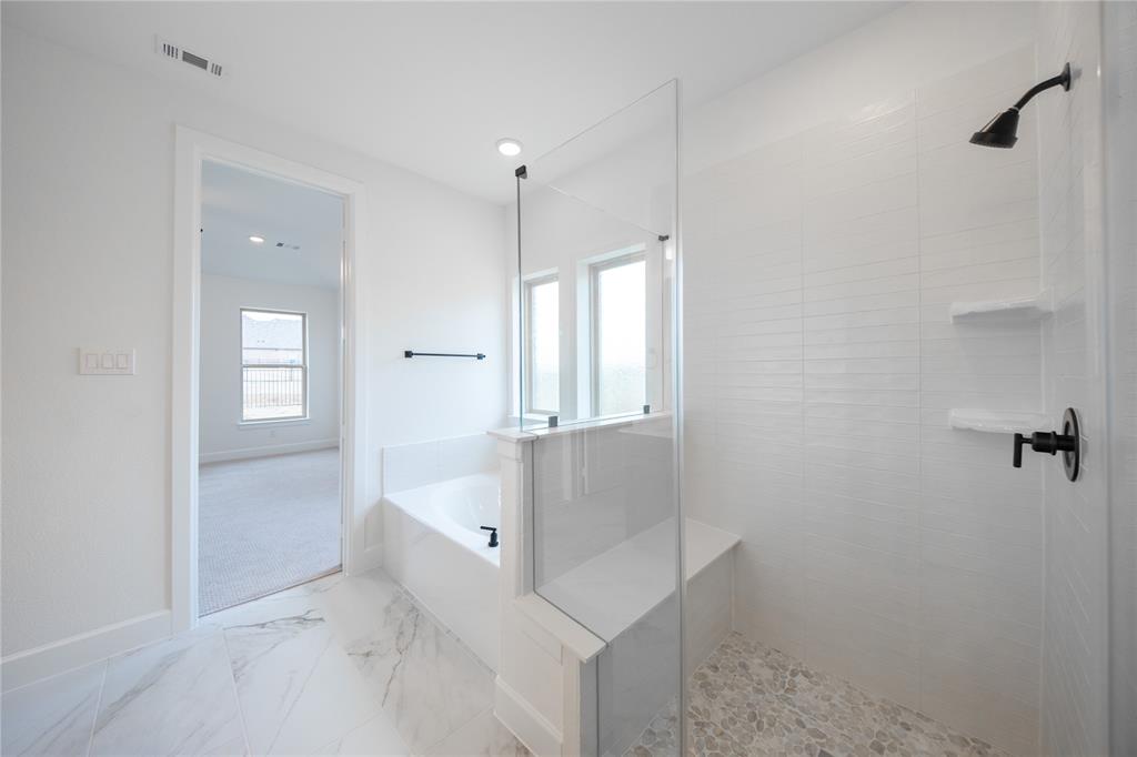 2715 Triumph Court Heath, TX 75126 - Photo 11 of 30 a bathroom with a bathtub and shower
