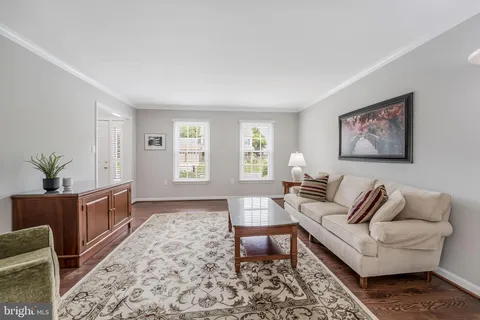 a view of a dining room and livingroom with furniture wooden floor a chandelier