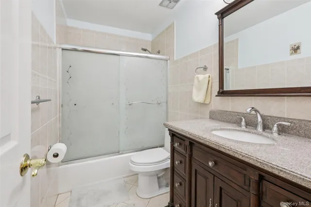 a bathroom with a granite countertop sink toilet a mirror and shower