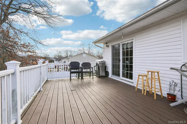 a view of a roof deck with table and chairs and wooden floor
