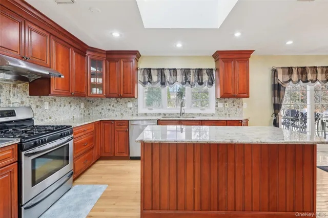 a kitchen with stainless steel appliances granite countertop wooden cabinets a stove top oven a sink and dishwasher