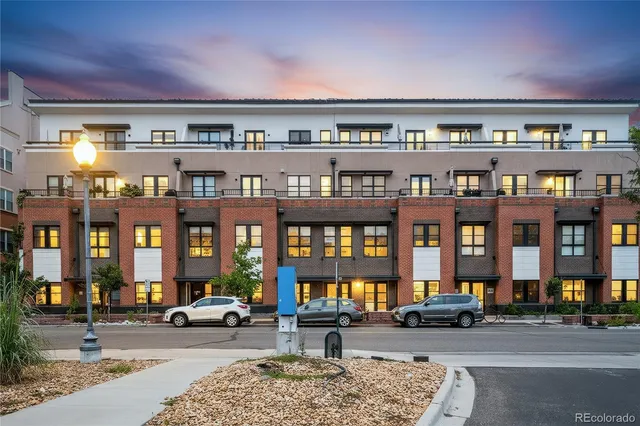 a city street filled with lots of tall buildings and cars parked