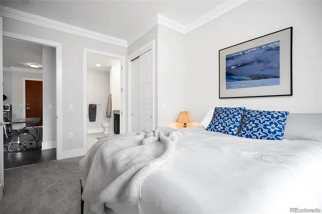 a bedroom with a bed and a painting on the wall