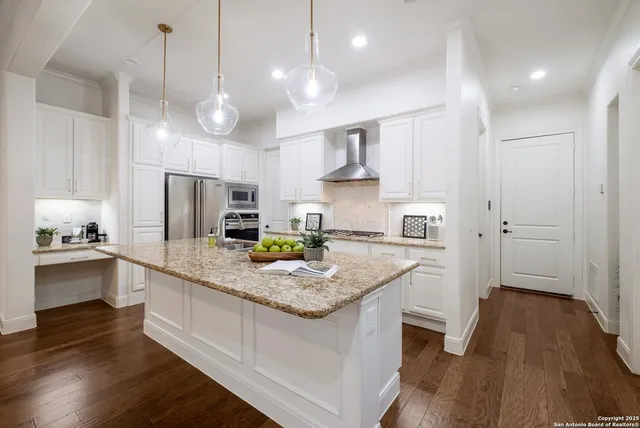 a kitchen with stainless steel appliances granite countertop a sink refrigerator and cabinets