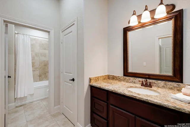 a bathroom with a granite countertop sink and a mirror