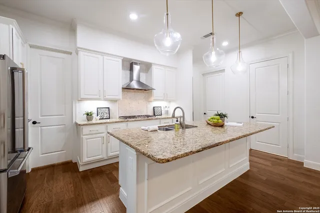 a kitchen with stainless steel appliances granite countertop a sink a refrigerator and a stove