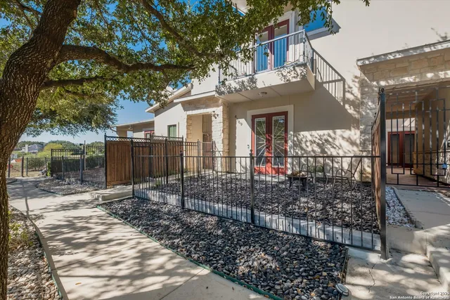 a view of a house with a small yard and a large tree