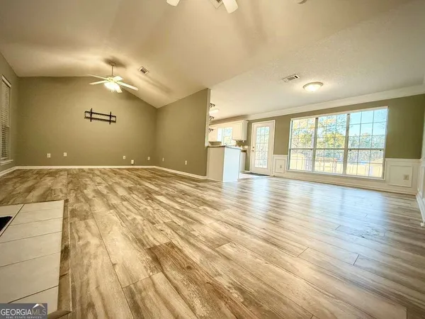 a living room with kitchen island granite countertop wooden floor and view living room