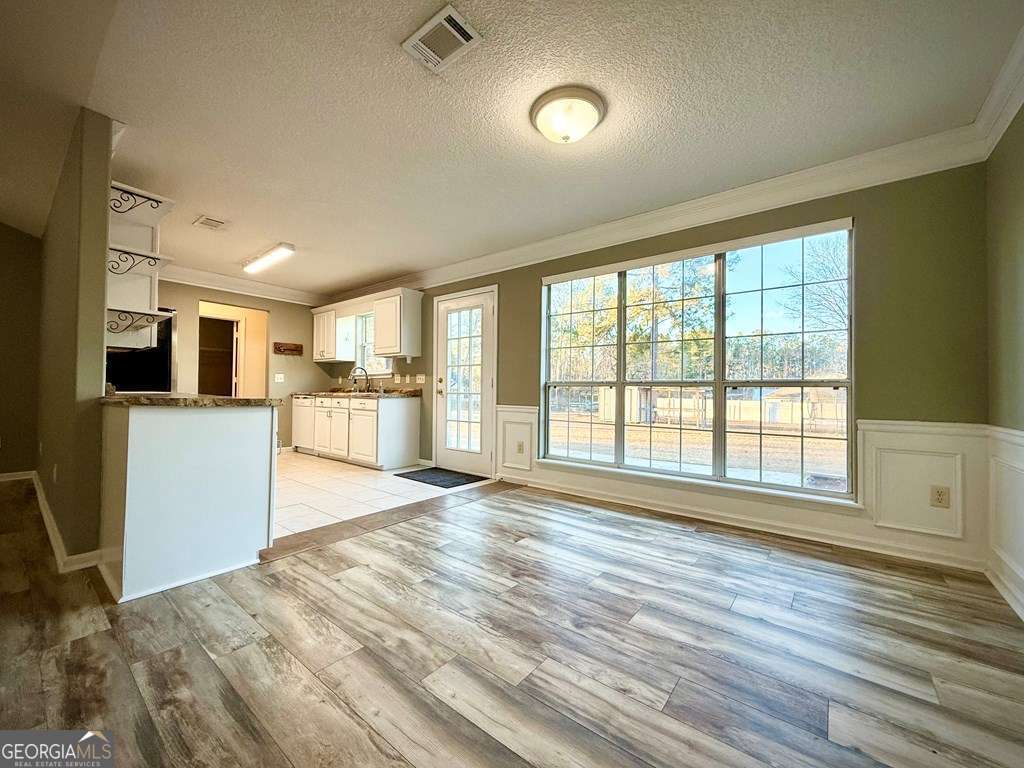 14 Quail Circle Hazlehurst, GA 31539 - Photo 13 of 54 a view of a kitchen and an empty room with wooden floor and a kitchen