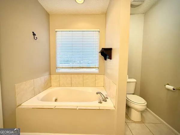 a spacious bathroom with a double vanity sink toilet and a mirror