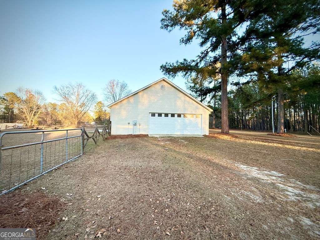 14 Quail Circle Hazlehurst, GA 31539 - Photo 4 of 54 a view of a white house with a large tree with wooden fence