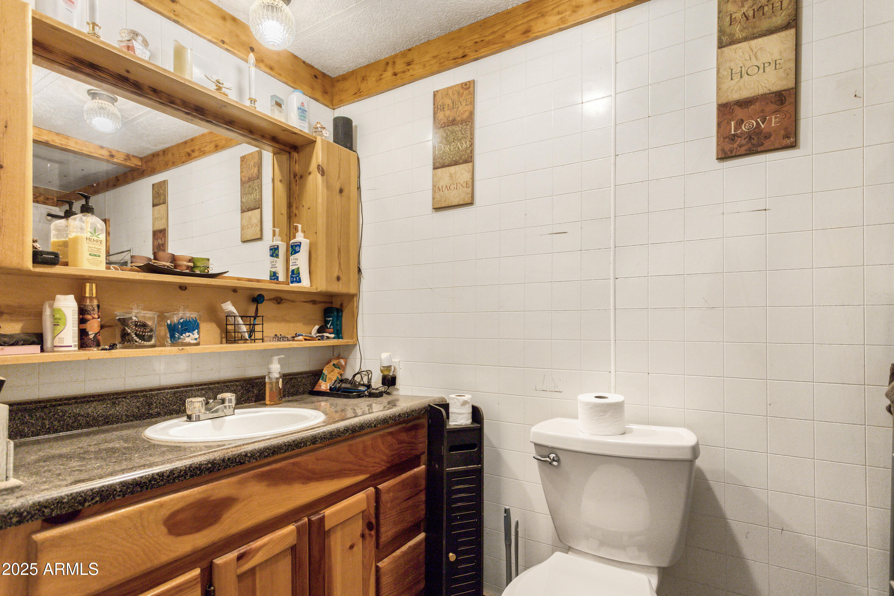 4274 West Lee Road McNeal, AZ 85617 - Photo 11 of 43 a bathroom with a granite countertop sink a toilet and a mirror