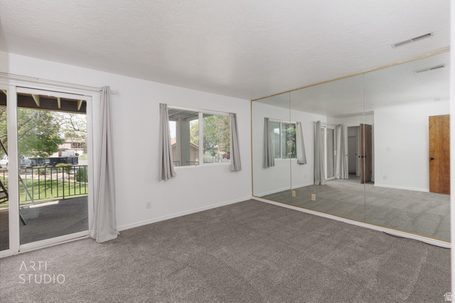 860 South Village Road, Unit A6 St. George, UT 84770 - Photo 8 of 41 Unfurnished bedroom with carpet floors, a closet, access to exterior, and a textured ceiling