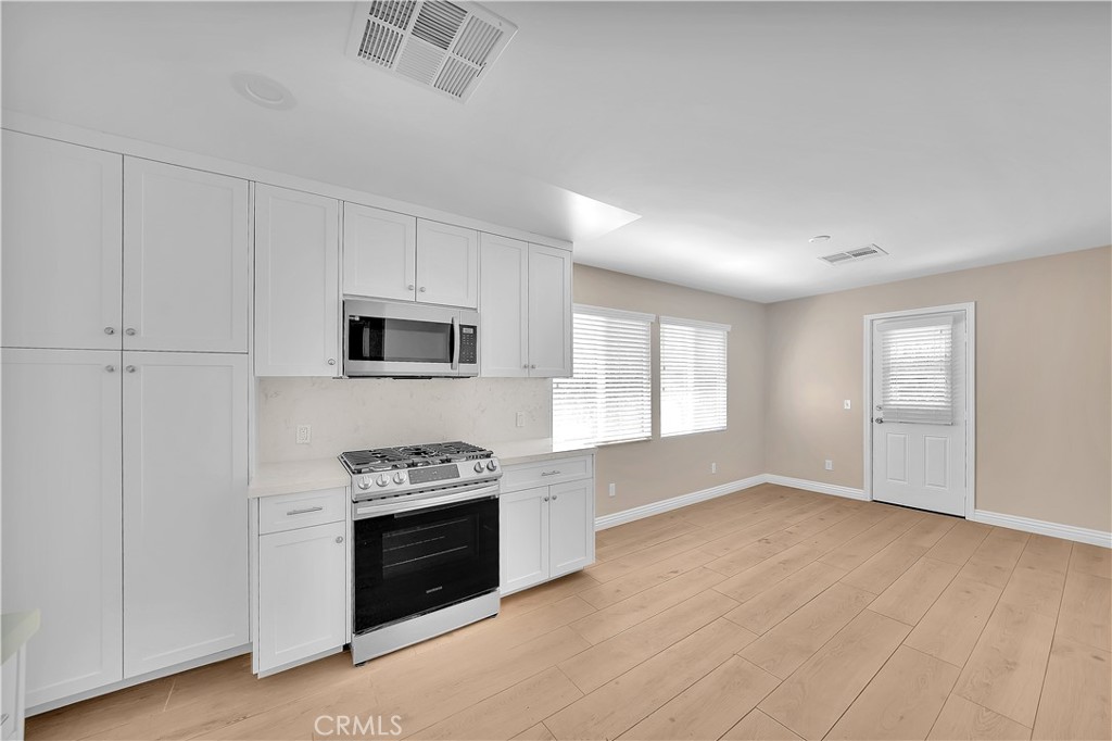 6735 B Yellowstone Drive Riverside, CA 92506 - Photo 3 of 15 a kitchen with granite countertop a stove top oven and cabinets