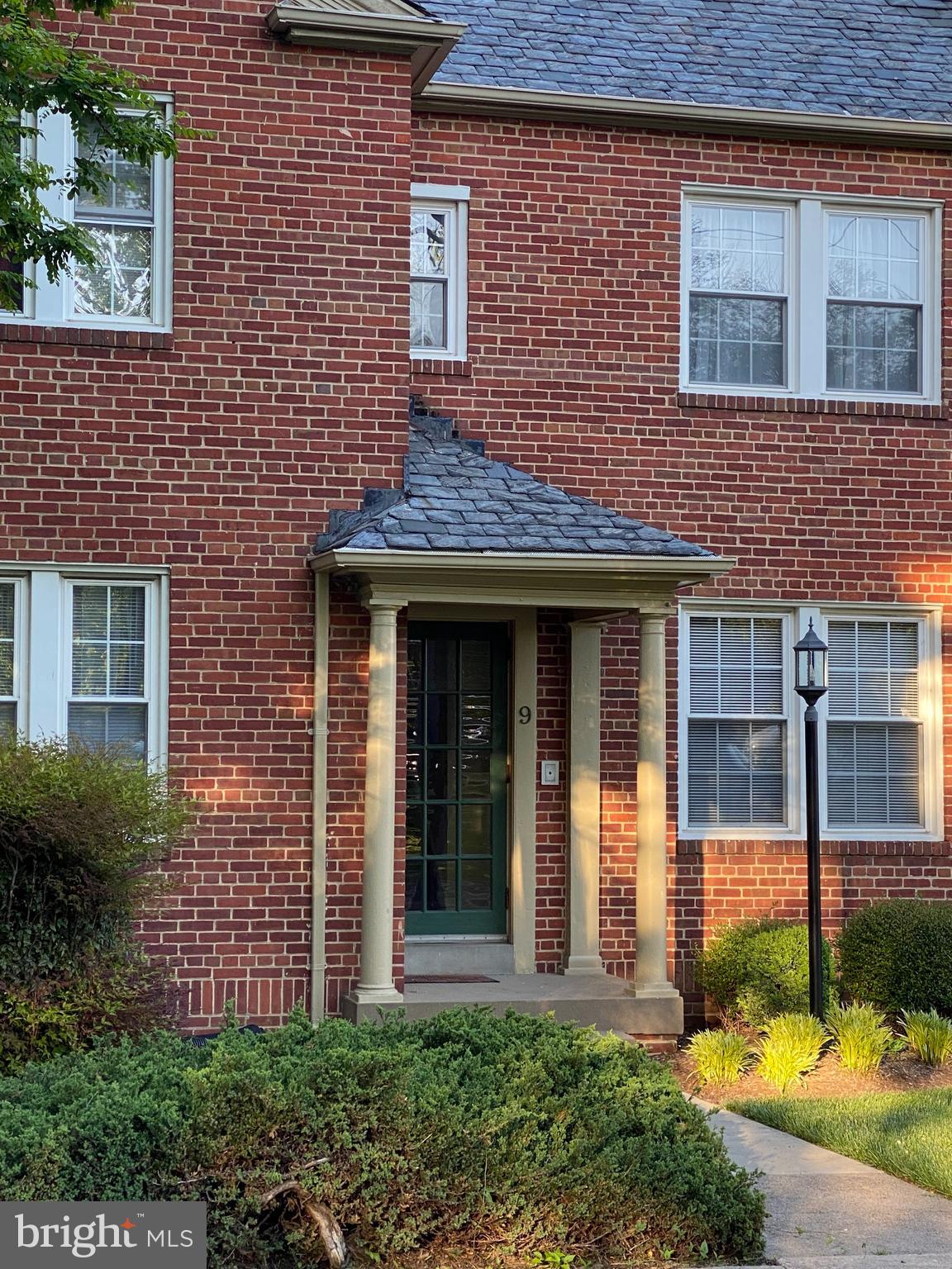 9 Russell Road, Unit D Alexandria, VA 22301 - Photo 3 of 29 a view of a brick house with plants and large tree
