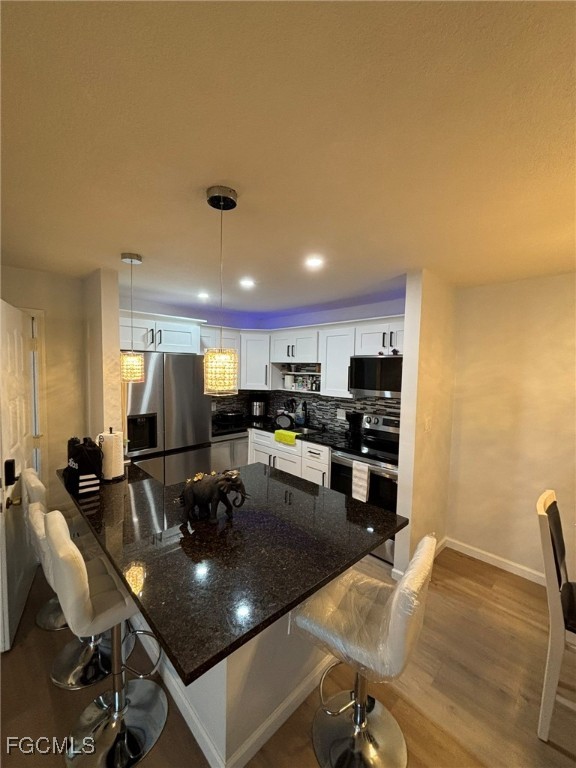 5713 Foxlake Drive, Unit 4 North Fort Myers, FL 33917 - Photo 4 of 13 a kitchen with a table chairs stove and kitchen island