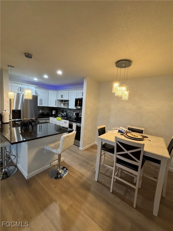 5713 Foxlake Drive, Unit 4 North Fort Myers, FL 33917 - Photo 5 of 13 a kitchen with a dining table chairs and a refrigerator