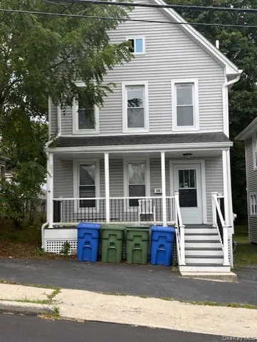 a view of a house with a yard and large trees