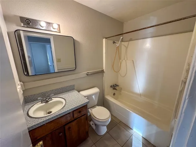 a bathroom with a granite countertop sink toilet a mirror a vanity and shower