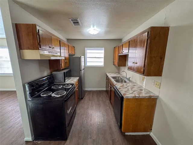 a kitchen with stainless steel appliances granite countertop a stove a sink and a refrigerator