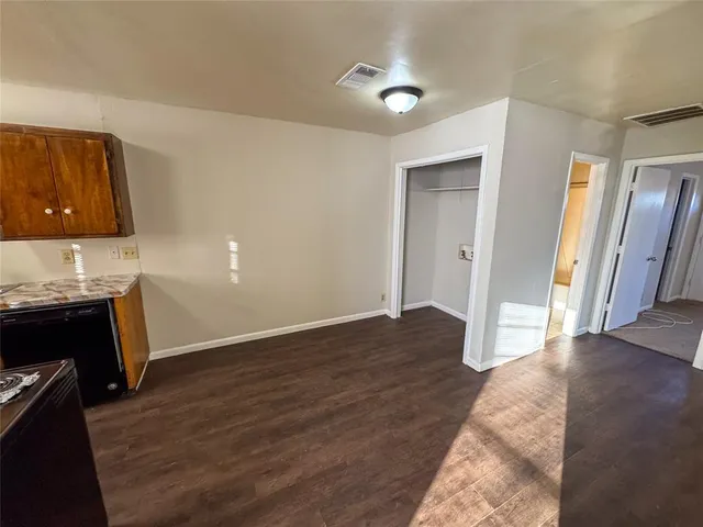 a view of empty room with wooden floor and cabinet