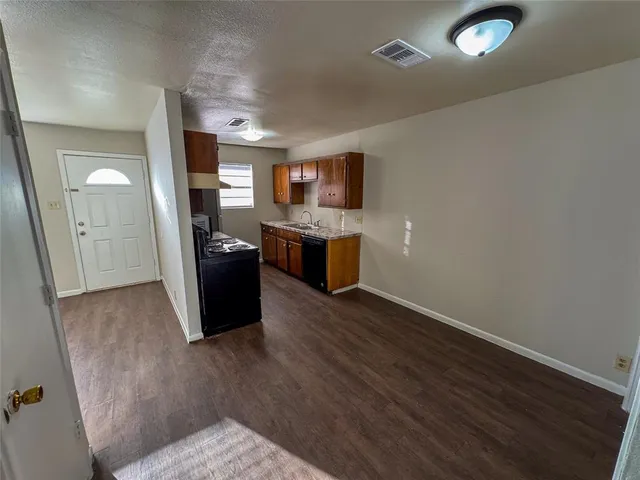 a living room with stainless steel appliances wooden floors and view living room