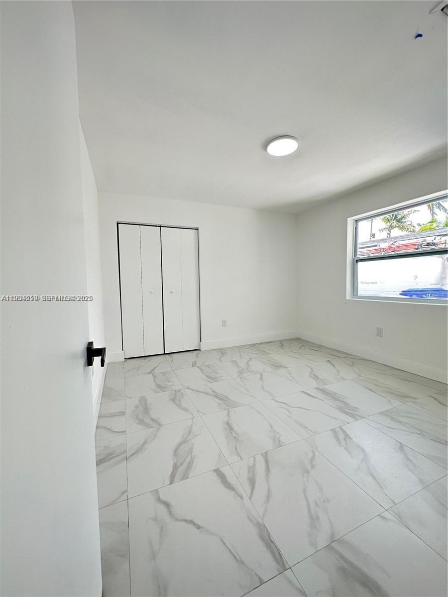 1443 Northwest 34th Street Miami, FL 33142 - Photo 8 of 11 an empty room with windows and closet