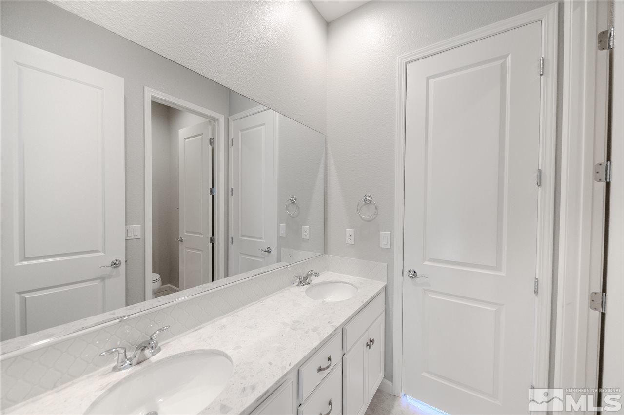 9485 Hawkshead Road, Unit LOT #87 Reno, NV 89521 - Photo 8 of 13 a bathroom with a granite countertop sink and a mirror