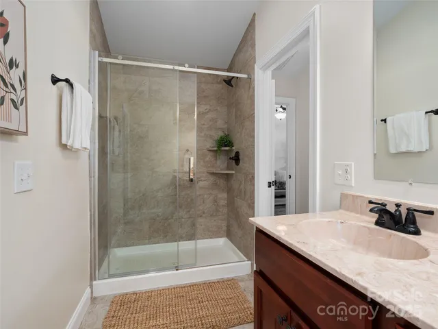 a bathroom with a granite countertop sink a shower and a mirror
