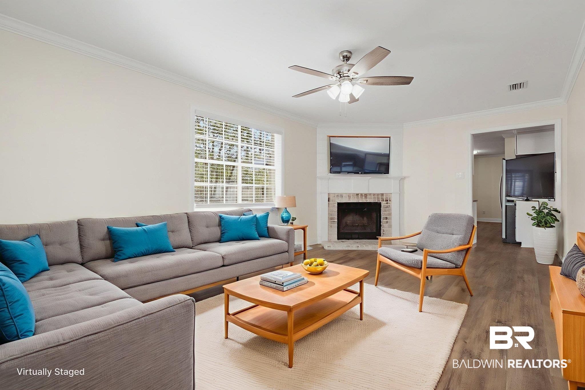 814 Nassau Drive Mobile, AL 36608 - Photo 11 of 44 Living area with ornamental molding, wood finished floors, a brick fireplace, and a ceiling fan. AI Generated.