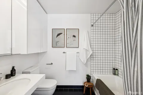 a bathroom with a toilet sink vanity tub and mirror