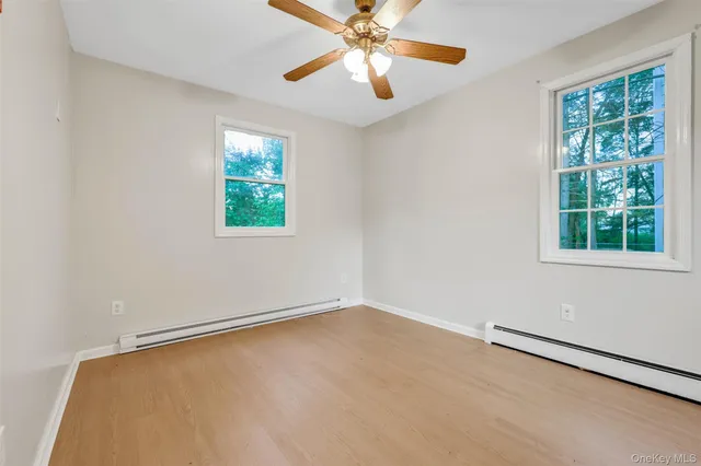 an empty room with windows and fan