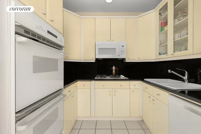 a kitchen with granite countertop white cabinets and black appliances