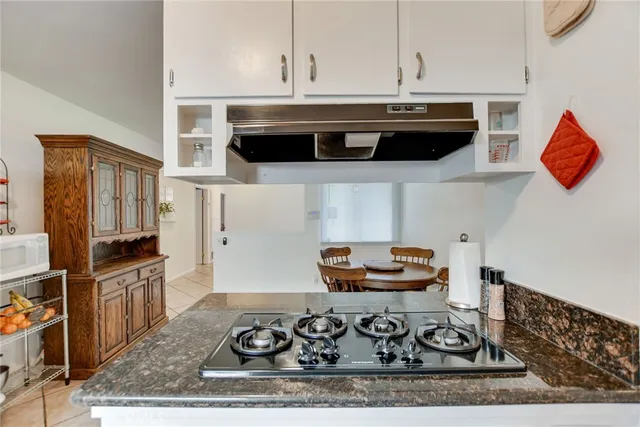 a kitchen with granite countertop white cabinets and a sink