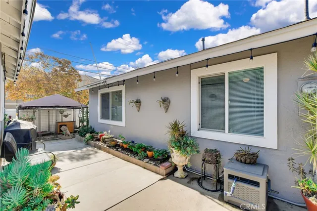 a view of a patio with plants and table and chairs under an umbrella