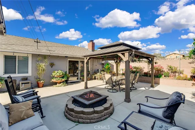 a view of a patio with dining table and chairs with a fire pit