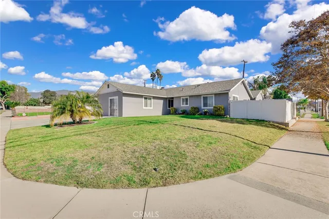 a view of a white house with a swimming pool and a yard