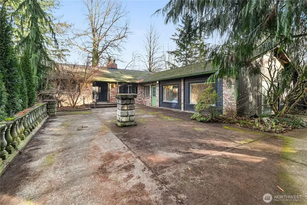 a front view of a house with garden and trees