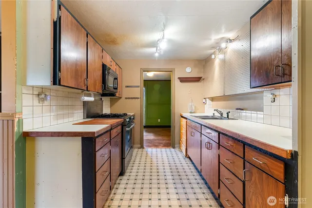 a large kitchen with stainless steel appliances granite countertop a sink and cabinets
