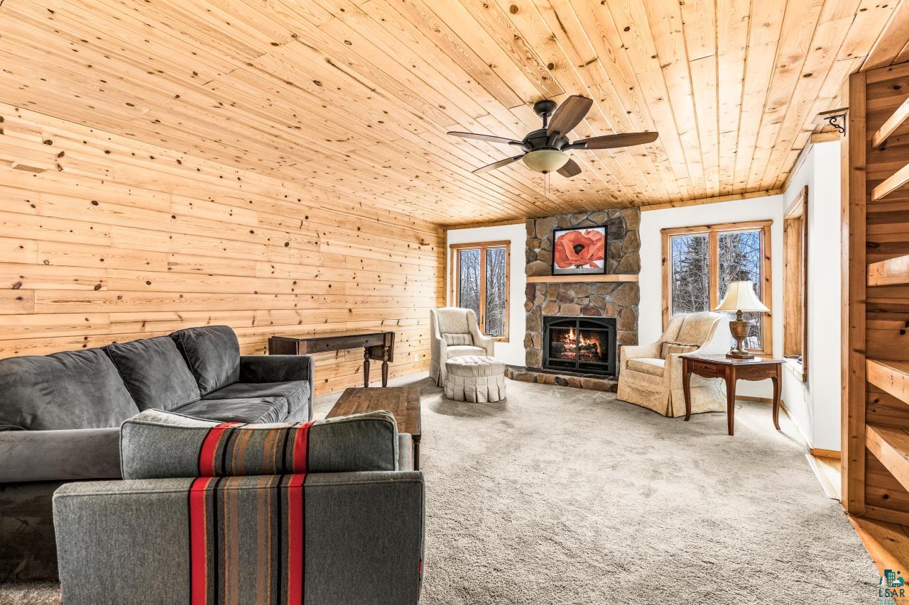 67 Snowshoe Trail Tofte, MN 55615 - Photo 14 of 42 Living room featuring wooden walls, carpet floors, a fireplace, wooden ceiling, and ceiling fan